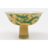 A Chinese porcelain sgrafitto decorated yellow ground stem bowl: the exterior incised and picked