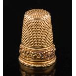 A 19th century gold thimble: with chased foliate frieze, 23mm long, apparently unmarked, 6.