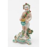 A Bow porcelain putti allegorical of Winter: modelled naked except for a holly wreath and garland