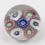 A Clichy glass paperweight: the clear ground set with a central circlet of blue and white canes