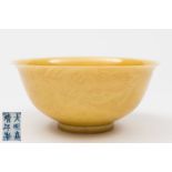 A Chinese porcelain sgrafitto decorated yellow ground bowl: the exterior incised with a pair of
