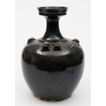 An Oriental black glazed stoneware jar: of ovoid form with waisted neck and cup-shaped rim,