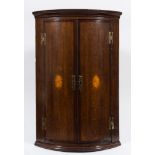 A late 18th/early 19th Century oak and mahogany and inlaid bow fronted hanging corner cupboard:,