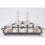 A late Victorian plated decanter stand: of rectangular outline, with gadrooned border,