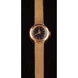 Omega. A lady's 18ct gold wristwatch: the circular black dial 14.