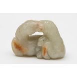 A Chinese jade carving of two reclining horses: with heads touching,