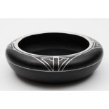 An Art Deco black and silver overlaid bowl: of shallow circular form the shoulders and neck with