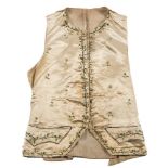 A Regency period cream silk waistcoat: the ivory ground with floral meander edging to the collar,