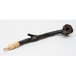 A Chinese black coral and ivory opium pipe: with naturalistic shaped bowl and stem with ivory