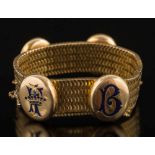A 19th century gold mesh bracelet: with four applied enamelled oval lockets,
