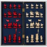 An early 20th century Chinese ivory chess set: one side stained red, the other natural ivory,