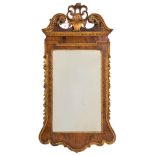 A late 19th Century walnut and carved giltwood mirror:, in the early 18th Century taste,