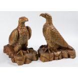 A pair of North Devon saltglazed stoneware eagles: with folded wings perched on a naturalistic base,