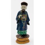 A Chinese sancai glazed figure of an official: wearing a blue robe and long necklace,
