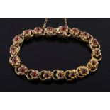 A 19th century gold and cabochon garnet mounted bracelet: of stamped flower-head links,