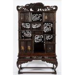 A late 19th Century Japanese carved wood and decorated cabinet on stand:,