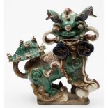 A large Chinese glazed stoneware figure of a Buddhist lion dog: decorated in green,