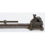 A late 19th century French small metal fender: the main rail terminating with seated dogs on plinth