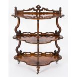 A Victorian walnut serpentine fronted three tier whatnot:,