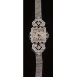 A lady's platinum, gold, diamond and black onyx cocktail wristwatch: the dial with Arabic numerals,