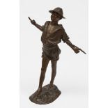 A Continental bronze figure of a boy: wearing a straw hat with stick behind his back,