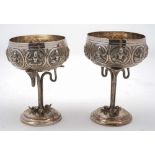 A pair of Indian silver goblets: the circular bowl decorated with roundels depicting dancers,