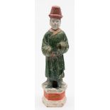 A Chinese pottery figure of a Court attendant with detachable head: wearing a high red hat and