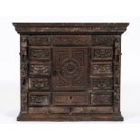 An early 18th century Italian carved walnut cabinet: decorated with paterae, masks,