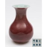 A Chinese porcelain peach bloom vase: of squat baluster form the pale flambé glaze darkening