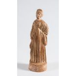A Roman hollow cast terracotta figure of a young woman: wearing long flowing robes, on oval base,