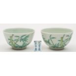 A pair of Chinese porcelain wine cups: each of circular form, the exterior enamelled with bamboo,
