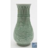 A Chinese celadon glazed vase: of tapering form the body carved with a pair of dragons competing