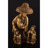 A late 19th century Japanese carved ivory okimono: of a woman wearing a domed wicker hat with three