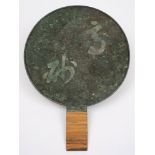 A Japanese bronze hand mirror: one side polished, the other cast with two large characters,