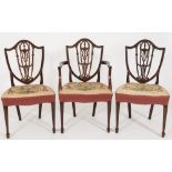 A set of eight late 19th Century carved mahogany dining chairs:, in the Hepplewhite taste,
