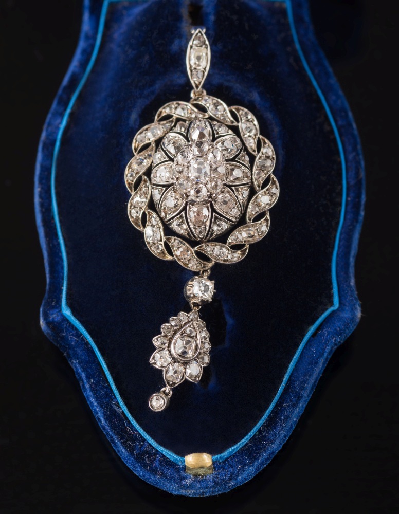 A late 19th century diamond mounted oval pendant: with central raised floral dome within an