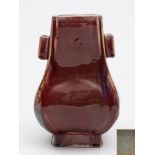 A Chinese flambe-glazed porcelain vase, Fanghu: of pear-shaped rectangular form with lug handles,