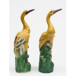 An opposing pair of Chinese porcelain figures of cranes: each with arched necks and one leg raised