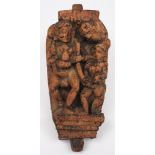 An 18th century Indian carved hardwood erotic figure group panel: the figures standing on a plinth