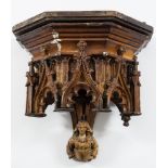 A 19th century Gothic carved oak wall bracket: the moulded pediment with blind arched arcaded