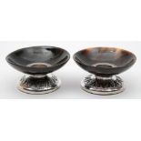 A pair of horn and white metal desk candlesticks: of low circular form with weighted bases, 8cm.