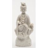 A Chinese Dehua blanc de chine porcelain figure of Guanyin: robed and in seated posture on a rocky