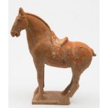 A Chinese terracotta figure of a horse: standing four-square, on plain rectangular base,