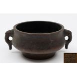 A Chinese bronze censer: of ogee form with pierced mythical beast head handles,