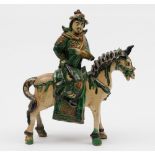 A Chinese 'sancai' glazed equestrian figure of a warrior: wearing ornate tunic and decorated in
