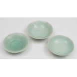 Three Chinese porcelain pale celadon bowls: of thinly potted form with petal shaped rims the centre