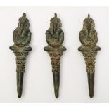 Three Khmer 13th century post Bayon bronze pendants: of Ganesha seated cross legged on tapering