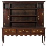 An 18th century and later oak dresser:, the shelved superstructure with a moulded cornice,