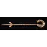 A late 19th century gold and diamond mounted horseshoe stick-pin: with graduated round old