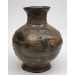 A large Chinese grey pottery jar: of baluster form with incised geometric bands and taotie mask